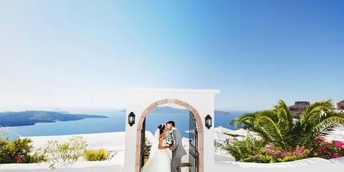 Wedding couple under arch in Santorini with sea view
